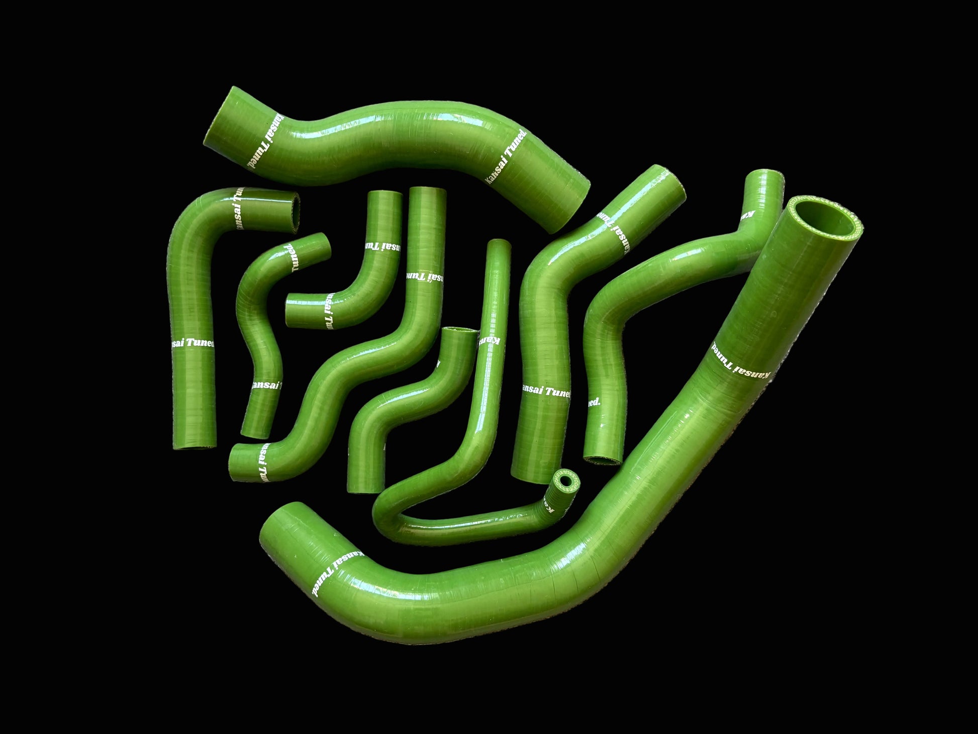 Set of green automotive hoses on a gray surface