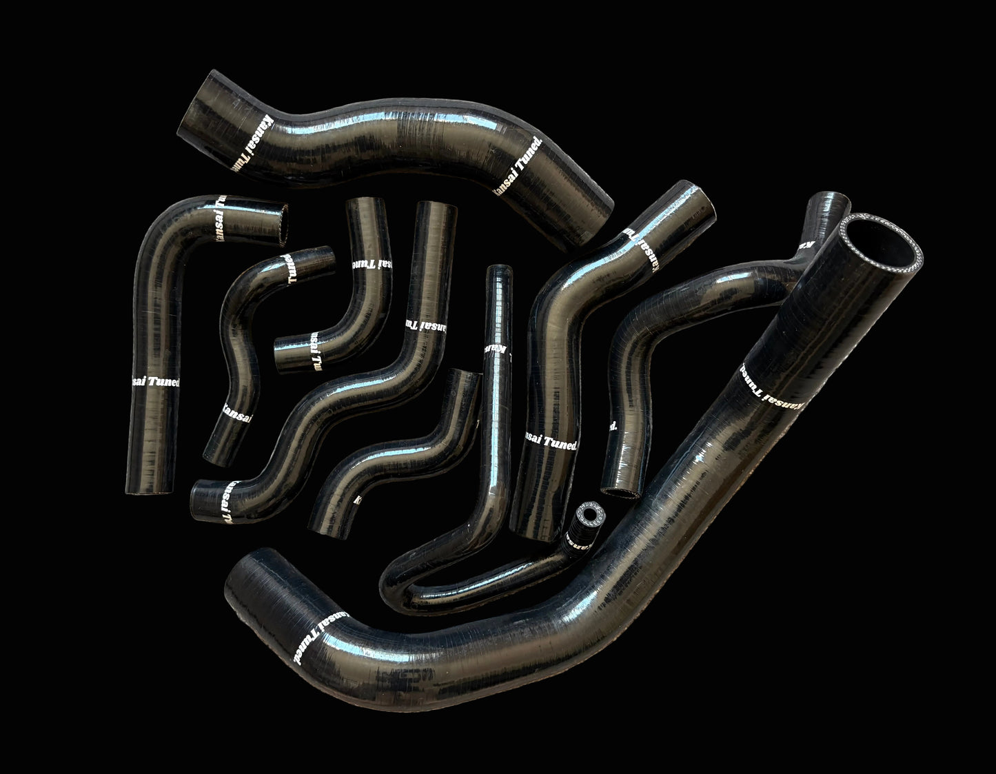 Set of black automotive hoses on a textured surface