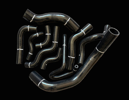 Set of black automotive hoses on a textured surface